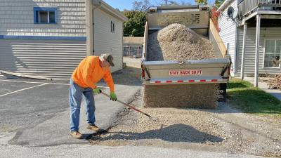 Village maintenance crew adding fresh gravel to an alley